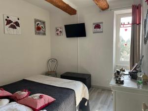 a bedroom with a bed and a tv on the wall at Mas de Maussan in Robion en Luberon