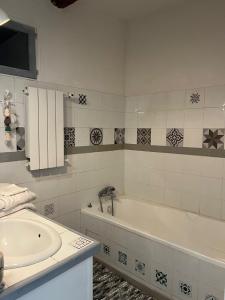 a white bathroom with a tub and a sink at Mas de Maussan in Robion en Luberon +5 photos