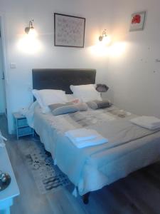 a bedroom with a large bed with white sheets and pillows at Mas de Maussan in Robion en Luberon