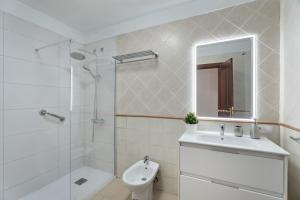 a white bathroom with a sink and a shower at Apartamento Estrella in Candelaria +17 photos