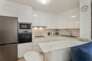 a kitchen with white cabinets and a blue couch at Apartamento Estrella in Candelaria