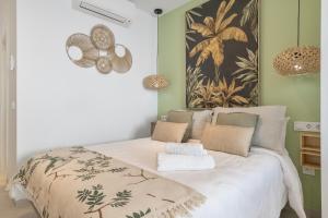 a bedroom with a bed with a large painting on the wall at Apartamento The Banana Tree 2 9 in Tarifa +16 photos