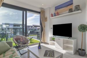 a living room with a tv and a large window at Atico de Lux Zahara in Zahara de los Atunes