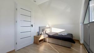 a bedroom with a bed next to a door at Domki i Apartamenty WiR na Kaszubach in Chmielno
