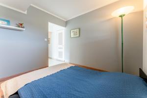 a bedroom with a blue bed and a lamp at Gîte du Badassier in Blauvac