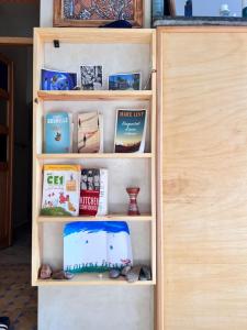 a wooden book shelf with books on it at Mirage House in Mirleft
