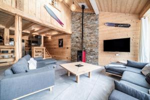a living room with two blue couches and a tv at Chalet Stéphane centre chatel in Châtel