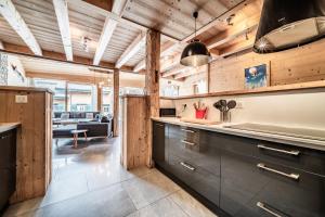 a kitchen with wooden ceilings and a living room at Chalet Stéphane centre chatel in Châtel
