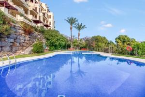 a swimming pool in a resort with trees and a building at Gadea Vistas in Caserío Capnegret