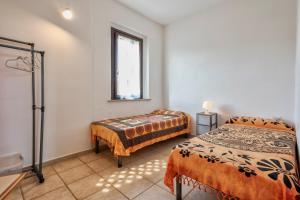 a room with two beds and a bench in it at Pergola 707 in Stintino