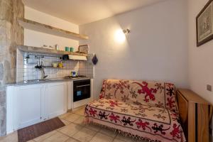 a living room with a chair and a kitchen at Pergola 707 in Stintino +11 photos