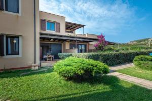 a house with a green yard in front of it at Pergola 707 in Stintino