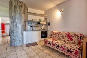 a living room with a couch and a kitchen at Pergola 707 in Stintino