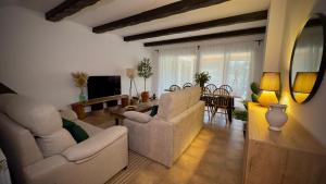 a living room with two couches and a dining room at Casa Rural El Olivo in Segovia