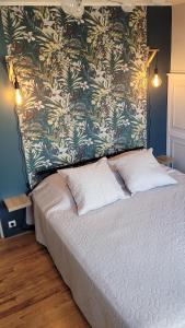 a bedroom with a large bed with a floral wall at Le Gîte du Chauze in Meyssac