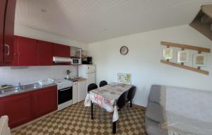 a kitchen with red cabinets and a table and a sink at Le Gîte du Chauze in Meyssac