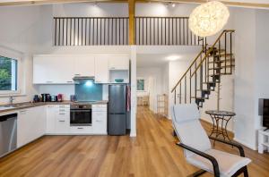 an open kitchen with white cabinets and a staircase at Ferienwohnung Vogesenpanorama in Bad Bellingen