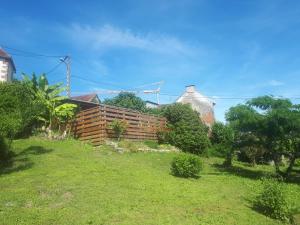 a house on a hill with a fence and trees at Le Gîte du Chauze in Meyssac