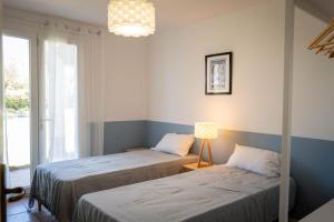a room with two beds and a lamp and a window at Bastide des vignes, piscine privée in Trèbes
