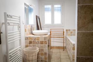 a bathroom with a sink and a bath tub at Bastide des vignes, piscine privée in Trèbes +11 photos