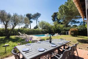 a long wooden table with chairs in a yard at Bastide des vignes, piscine privée in Trèbes