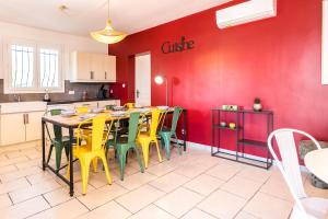 a kitchen with a table and yellow chairs at Bastide des vignes, piscine privée in Trèbes