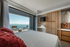 a bedroom with a bed and a large window with the ocean at River Villas Plomari - Luxury Villas with Direct Pool Access in Plomari +131 photos