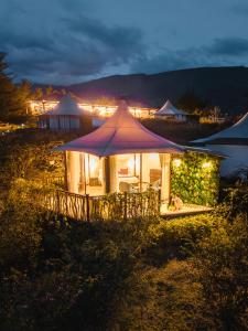 a lit up tent in a field at night at Hemma Genki Luxury Wellness Hotel Villa in Villa de Leyva