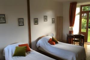 a bedroom with two beds and a desk and a window at Gites Du Château De Saveilles in Paizay-Naudouin +21 photos