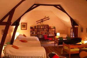 a living room with two beds and a book shelf at Gites Du Château De Saveilles in Paizay-Naudouin