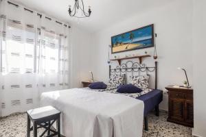 a white bedroom with a bed with blue sheets at Finca Alejandrina in La Guancha +14 photos