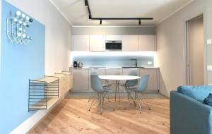 a kitchen and living room with a table and chairs at Palazzo Righi - App Blu in Carisolo
