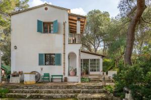 an old white house with green shutters at Son Oliver in Palma de Mallorca