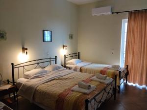 two beds in a room with towels on them at Evgenia Rooms in Skala