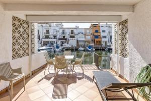 a balcony with a table and chairs and a view of a harbor at Port Empúries in Empuriabrava
