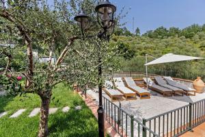a street light with lounge chairs and an umbrella at Villa Lepre in Casarza Ligure