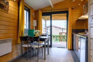 a dining room with a table and chairs in a kitchen at Chalet Spa 2 Terrasse des Bouleaux in Ranspach