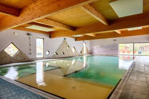an indoor swimming pool in a house with wooden ceilings at Chalet Spa 2 Terrasse des Bouleaux in Ranspach