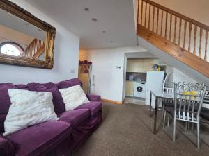 a living room with a purple couch and a table at Ramsgate Sea-side Stay! in Ramsgate