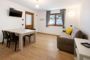 a living room with a table and a couch at Appartamenti Via Dell'Asilo in Valdidentro