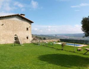 a large yard with a building and a pool at Mas Vinyoles in Centellas
