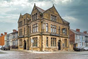 an old brick building on the corner of a street at The Stuart Hotel in Liverpool