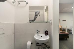 a white bathroom with a sink and a mirror at Cozy 2-bed Room With Kitchen W2 in Beckingen +8 photos