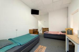 a bedroom with two beds and a desk and a table at Cozy 2-bed Room With Kitchen W2 in Beckingen