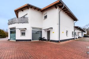 a white house with a red brick driveway at Cozy 2-bed Room With Kitchen W2 in Beckingen