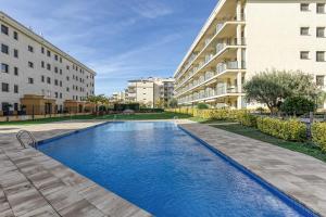 a swimming pool in front of two buildings at Roses Apartaments Luxury Duplex in Roses