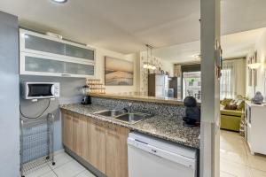 a kitchen with a sink and a microwave at Roses Apartaments Luxury Duplex in Roses
