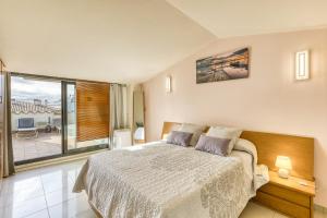 a bedroom with a bed and a large window at Roses Apartaments Luxury Duplex in Roses +21 photos
