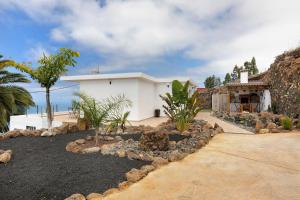 a white house with a church and palm trees at Casa Valista in Tijarafe