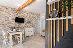a living room with a table and a clock on a brick wall at Casa Valista in Tijarafe